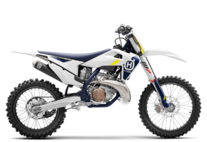 Das Bild zeigt ein modernes Husqvarna Motocross-Motorrad in weißer und blauer Farbgebung mit robusten Reifen und leistungsstarkem Motor.